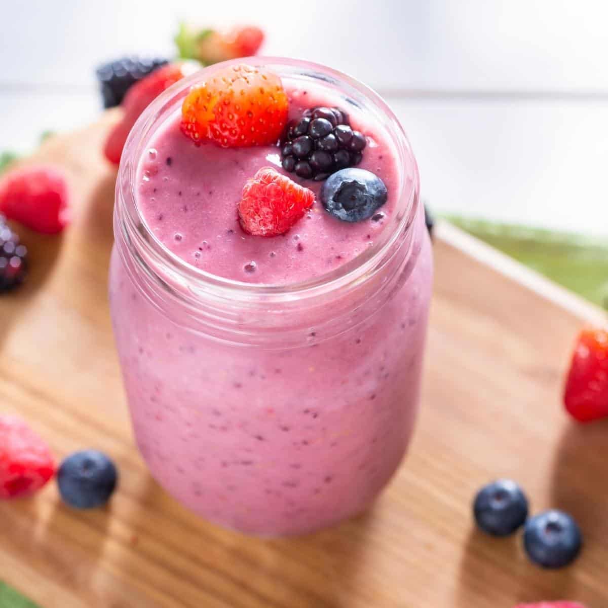 A pink smoothie in a clear glass jar.