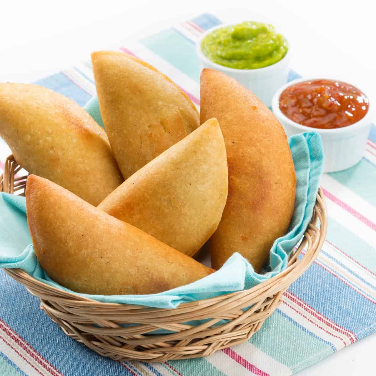 A wicker basket filled with empanadas.