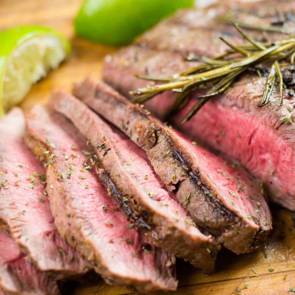 Sliced flank steak resting on a cutting board.