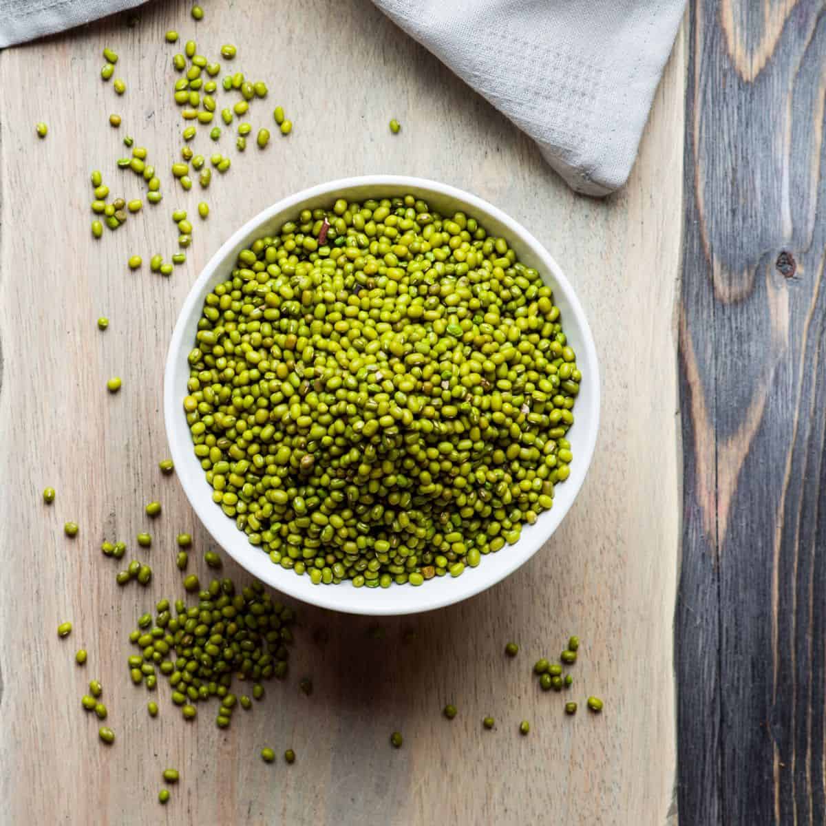 A white bowl filled with green mung beans.