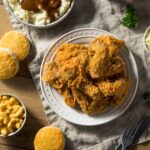 Fried chicken and sides on a wooden table.