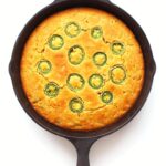 Cornbread with jalapeño slices baked in a cast-iron skillet.