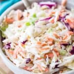 A close-up of fresh coleslaw with shredded cabbage and carrots in a bowl.