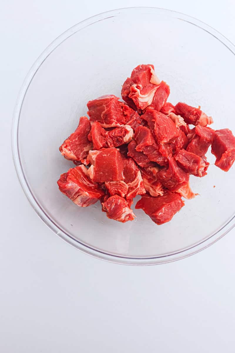 Air fryer steak bites in a glass bowl on a white background.